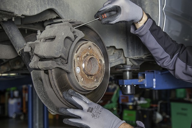Modern Automotive mechanic replacing brake pad and rotor